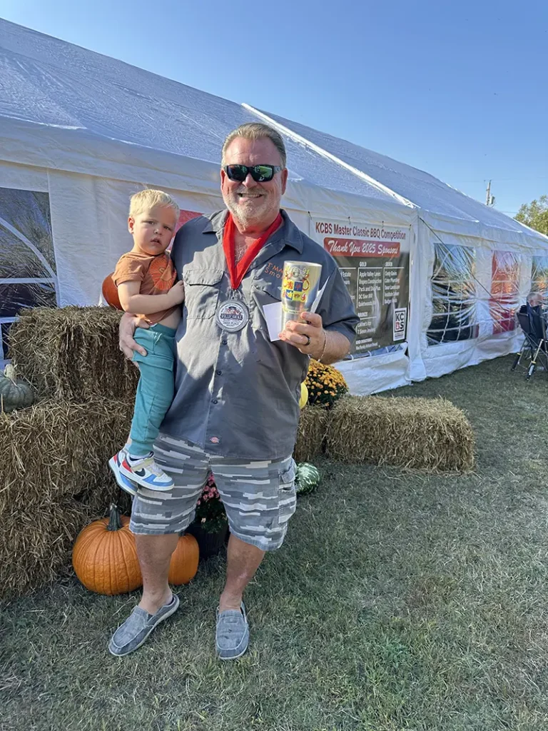2025 Rolling Smoke BBQ Bash winner holding child